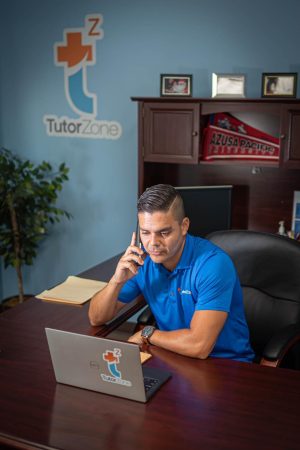 This is a photo of a tutor putting long hours of work into planning lessons for his students and better help them meet their educational goals. Photo credit: William Ebert