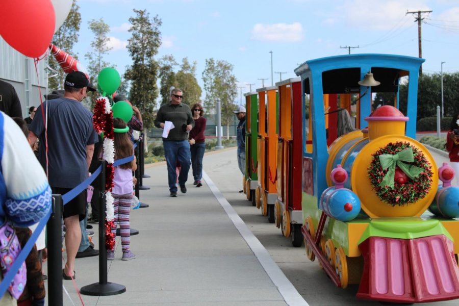 Families wait in line to ride the little train to give them a tour of Cerritos College on Dec. 10. 