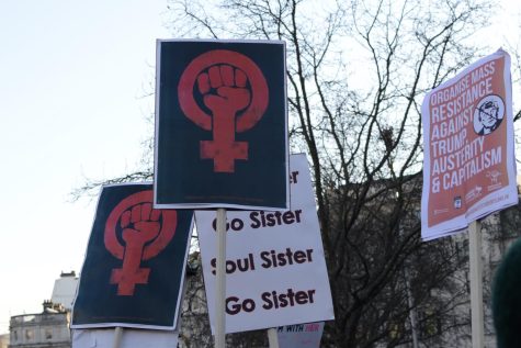 Protestors holding up signs of the female gender symbol at a march during the Womens March on London, Jan. of 2017. 