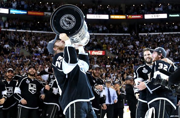 LOS ANGELES, CA - JUNE 11:  Captain Dustin Brown #23 of the Los Angeles Kings kisses the Stanley Cup as Jonathan Quick #32 and Simon Gagne #12 hug after the Kings defeated the New Jersey Devils 6-1 to win the Stanley Cup final series 4-2 after Game Six of the 2012 Stanley Cup Final at Staples Center on June 11, 2012 in Los Angeles, California.