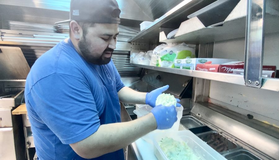 Eder Rivas demonstrating how to make a pupusa inside their food truck Whats That Youre Cookin?