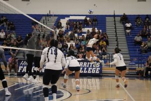 Jasmine Soto No.18 gets air as she leaps up to defend the ball from hitting the floor.