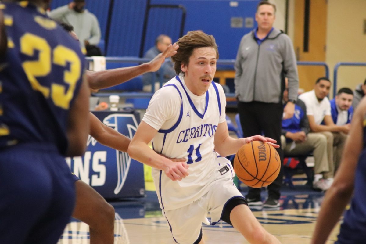 Everett May driving down the court while being defended by LA Southwest players. 