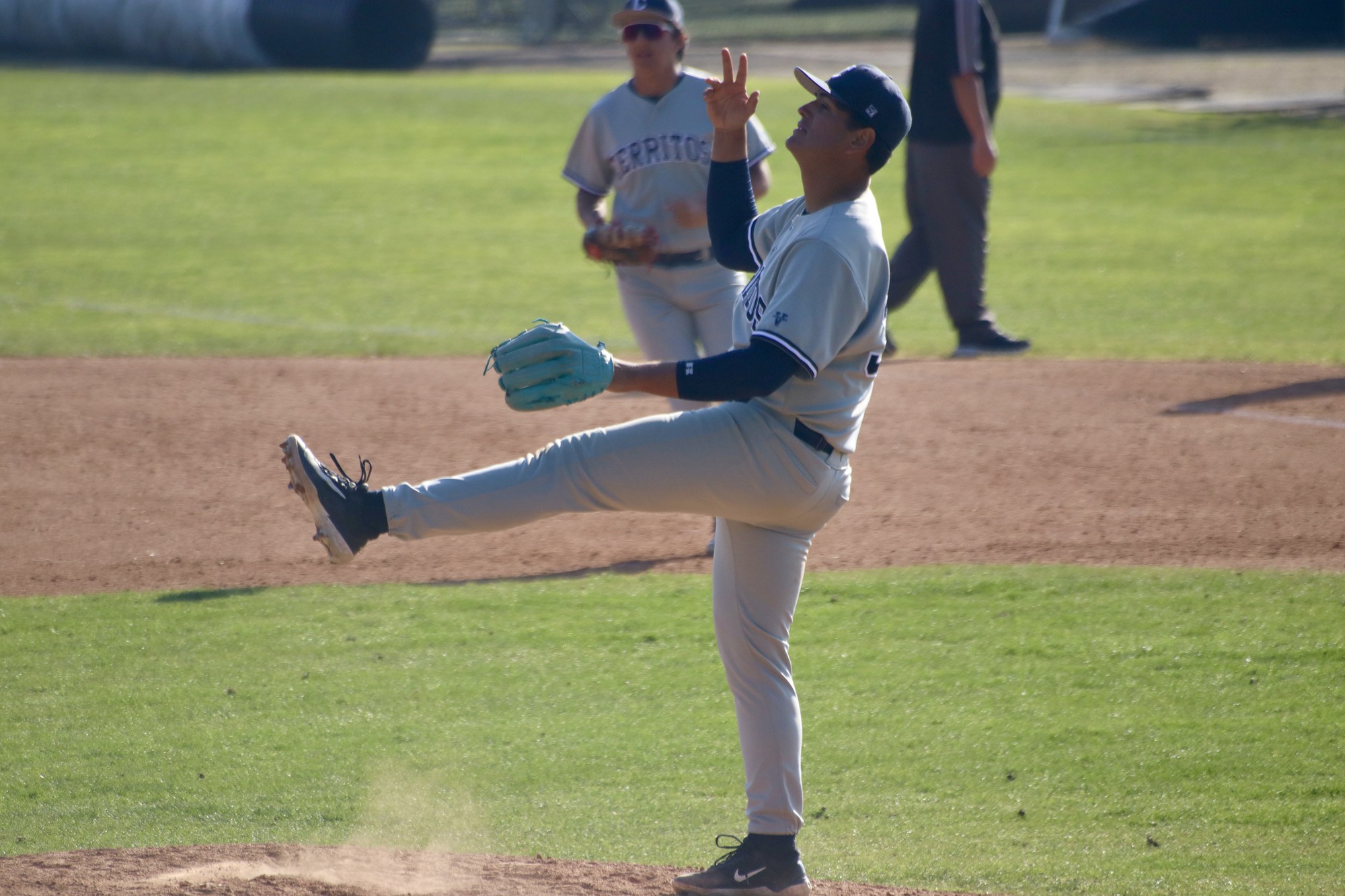 Pitcher, Franky Lopez, kicking his leg in the air and raising his arm after recording the final out to finish the complete game. 