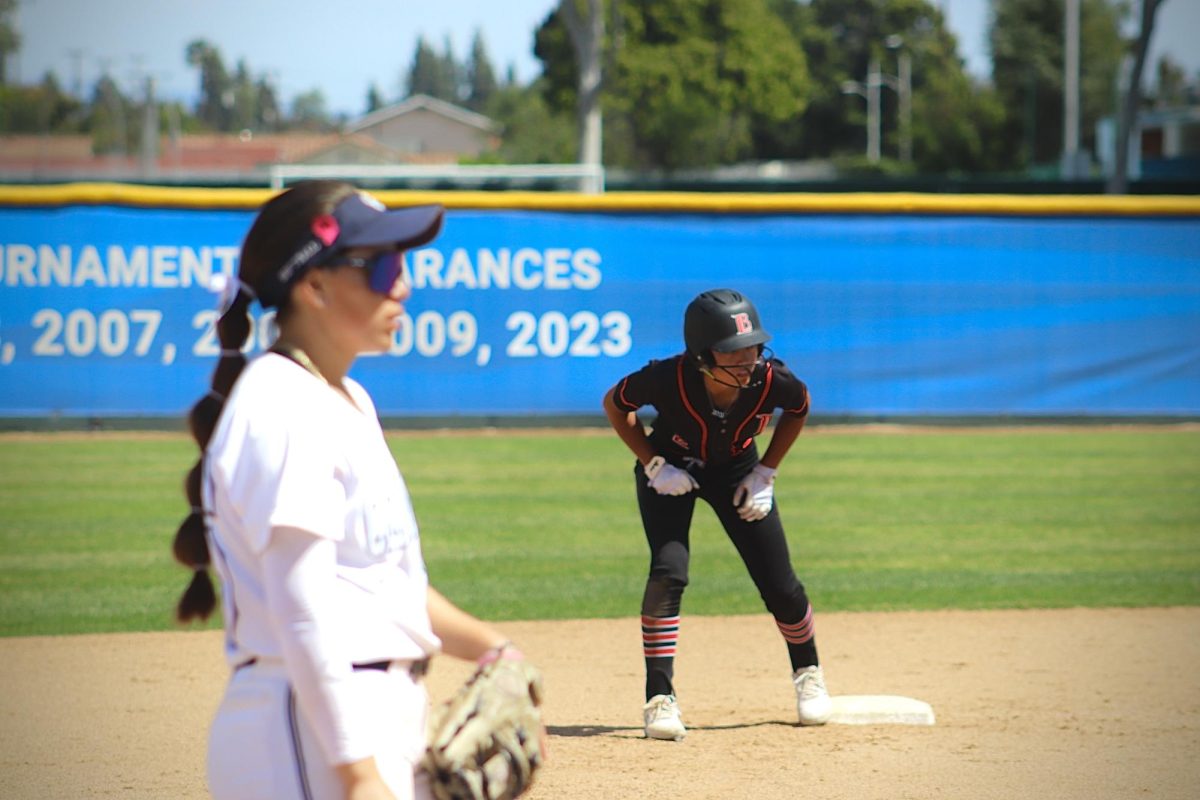 Natalie Basurto watching the pitch while Xiomei Geluz from LBCC attempts to steal base.