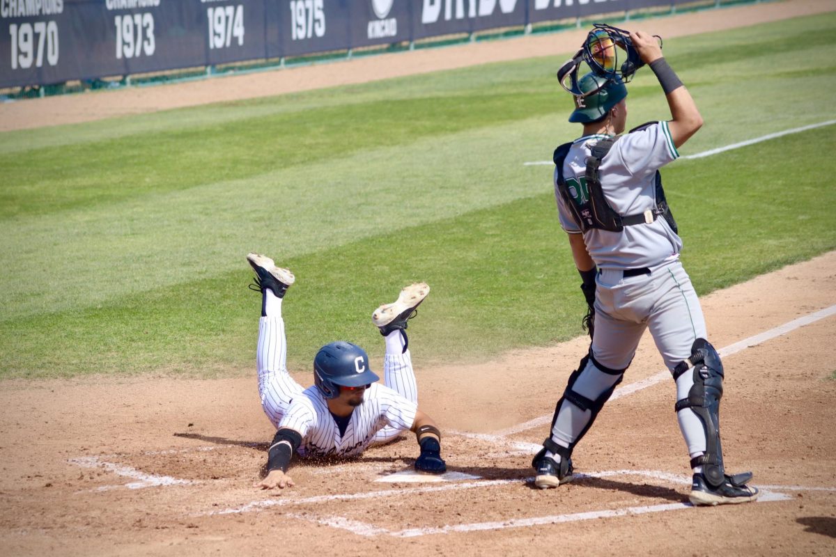 Infielder, Anthony Bassett, sliding head first into home plate and scoring.