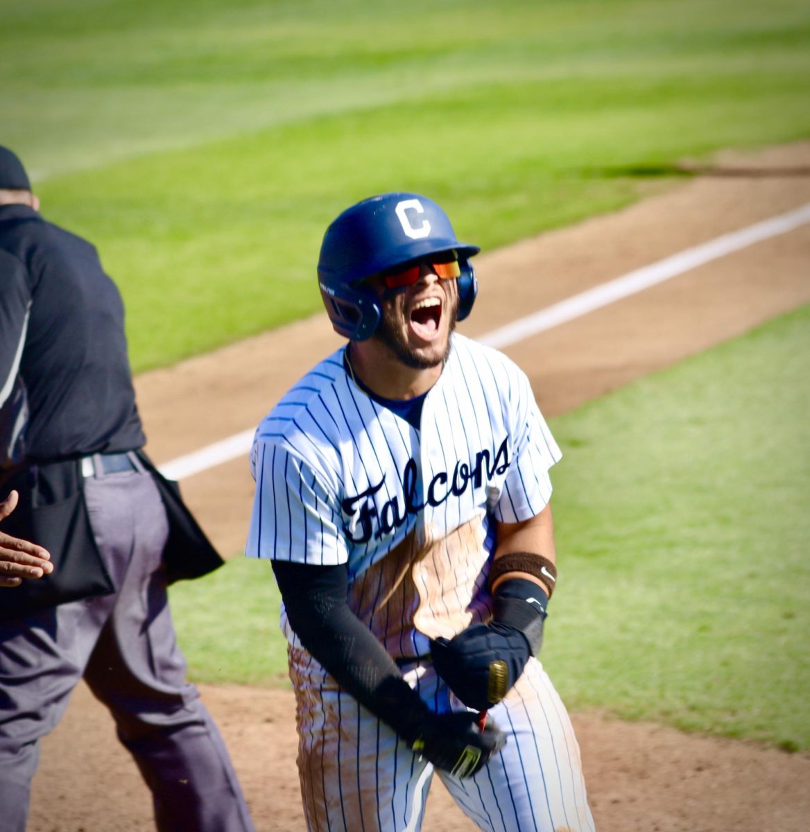 Anthony Bassett, infielder yelling while putting his arms together after scoring. Photo credit: Joel Carpio