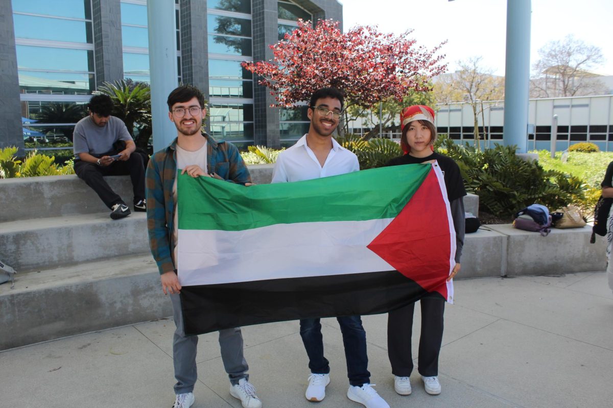 Carlos Vazquez (left) Andes Juarez (middle) and Ashley Yim (right) holding Palestinian flag 