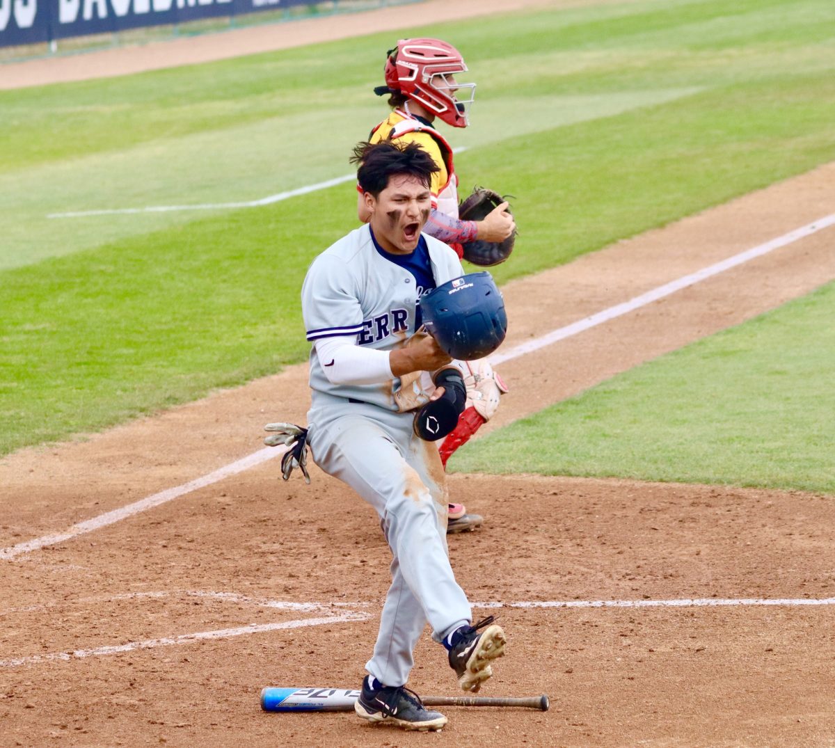 Outfielder, Nico Briones yelling and pumped after scoring at home from second base. 