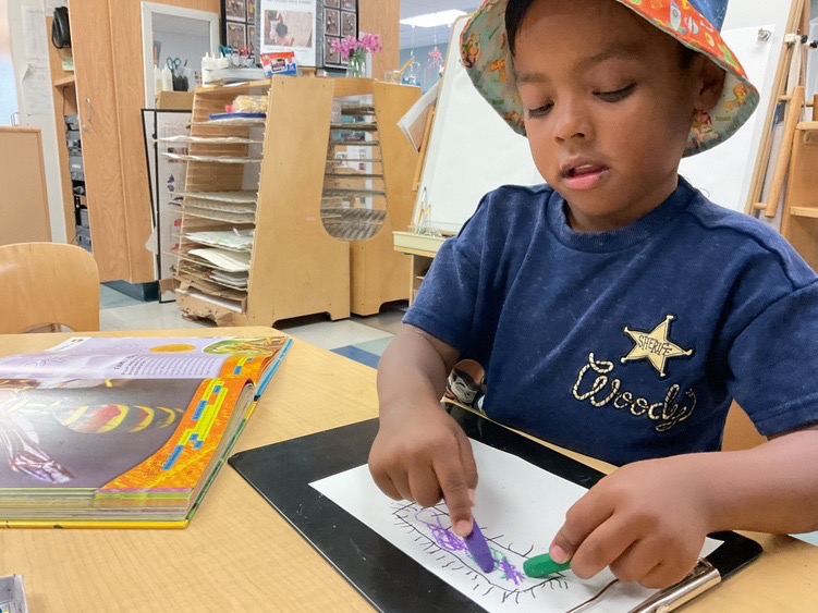 Mars, a child of a student currently at Cerritos, enjoys drawing and playing while at the Child Development Center.