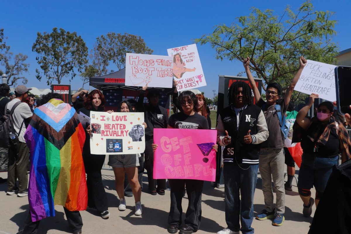 Multiple students are pictured with their signs protesting against Kristian Hawkins