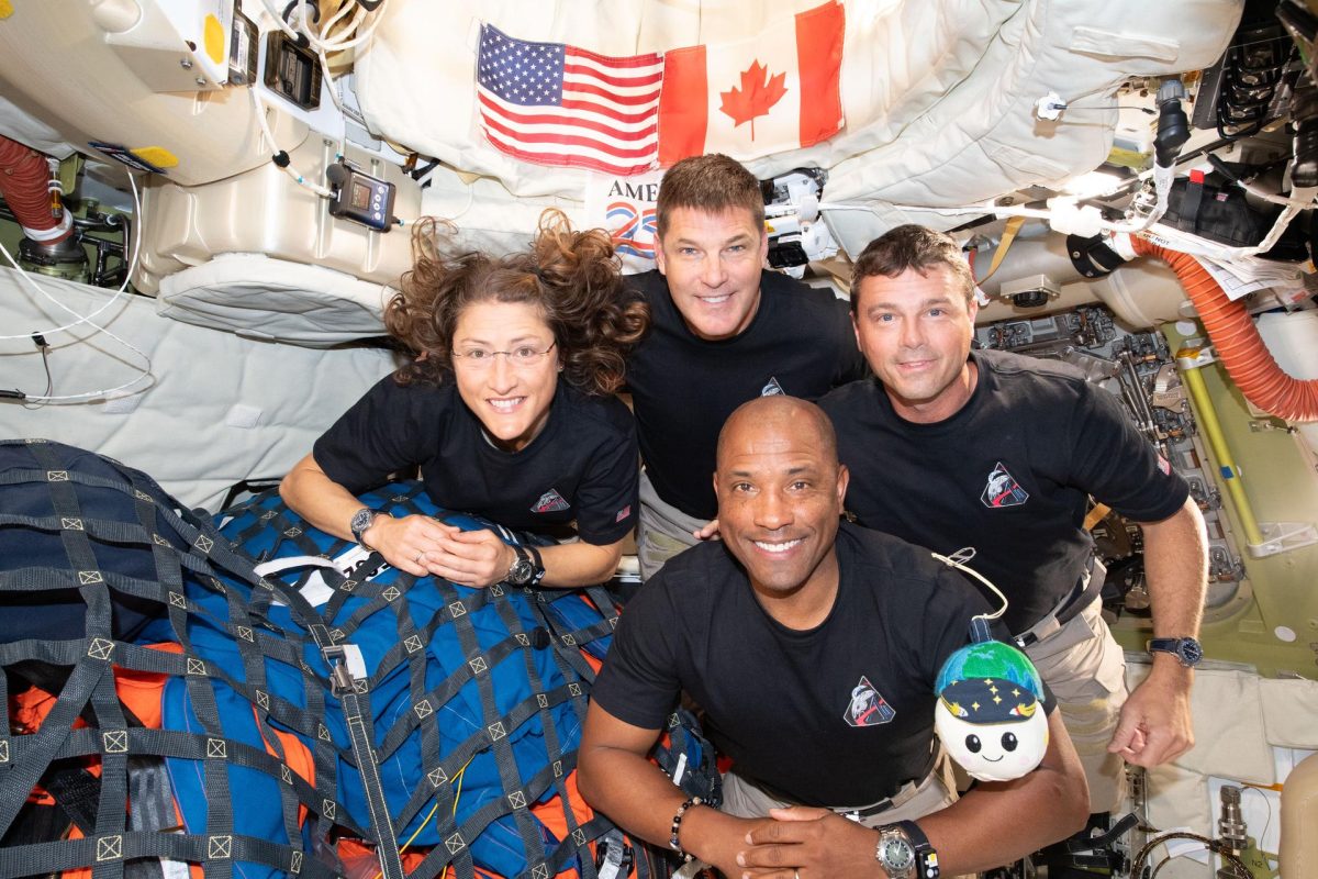 The Artemis II crew – (clockwise from left) Mission Specialist Christina Koch, Mission Specialist Jeremy Hansen, Commander Reid Wiseman, and Pilot Victor Glover – pause for a group photo with their zero gravity indicator "Rise," inside the Orion spacecraft on their way home.