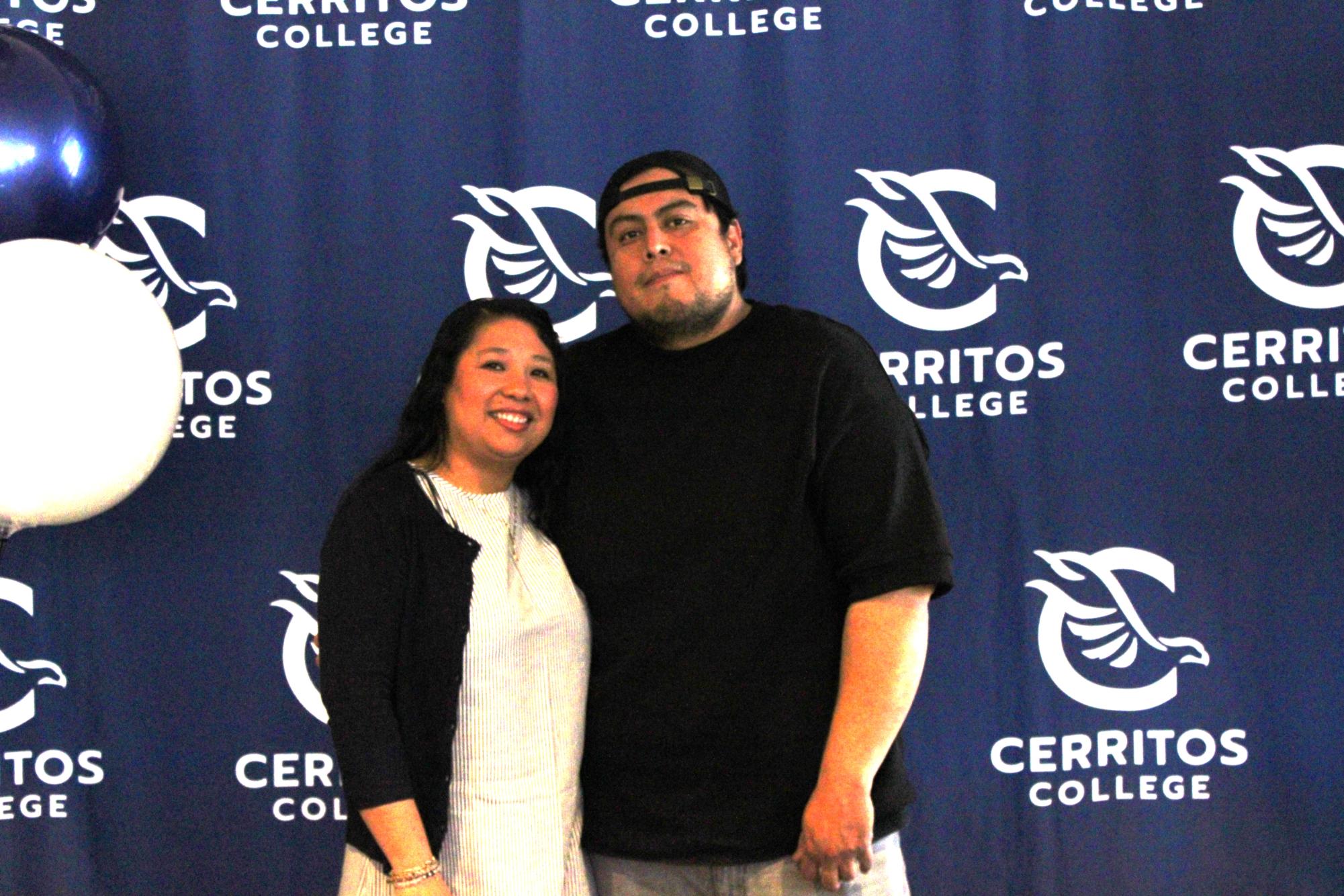 Karen Velez appears alongside a companion as they pose in front of the Cerritos College institutional backdrop during the EOPS event. Student Center Cerritos College on Wednesday, May 14, 2026.